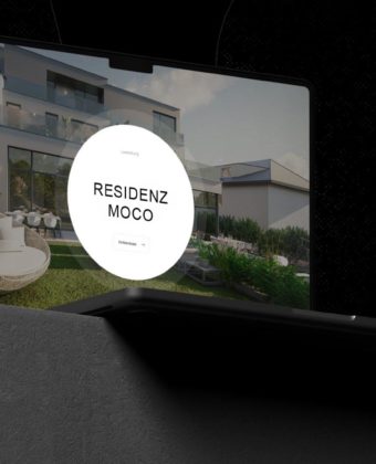 Ein Foto eines Laptops, welches auf einem Sockel steht und auf der die MIMCO-Website mit der Residenz MOCO geöffnet ist.